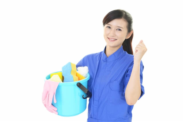 バケツに入れた清掃用品を片手に持ち、ガッツポーズの女性